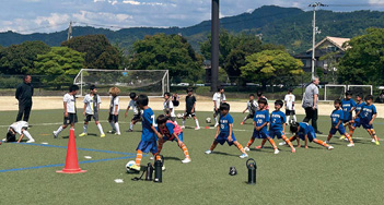 Children practicing soccer under the guidance of professional coaches