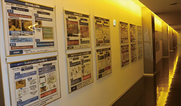 Panels detailing past challenges, successes, and examples of improvements displayed in the factory corridors
